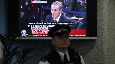 A police officer stands in front of a television screen in the foyer of the venue hosting the Chilcot Inquiry in London in 2010. The inquiry's conclusions have still not been released.
