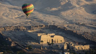 A hot air balloon flying over an ancient temple on the west bank of the Nile River in Luxor, Egypt, 2016. 
