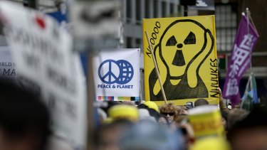 People hold signs during an anti-nuclear rally in Union Square in New York on Sunday.