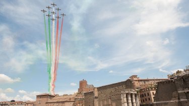 The Frecce Tricolore air squadron flies over the Via dei Fori Imperiali during the military parade to mark the founding of the Italian Republic and the 150th anniversary of Italian unification after the death of Benito Mussolini. 