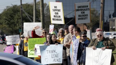 People hold signs during a rally to show support for Muslim members of the community near the Clear Lake Islamic Centre in Webster, Texas, on Friday.