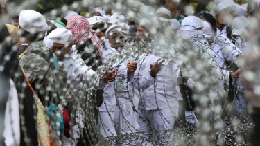Muslim protesters are seen through razor wire barricades during a rally against the persecution of Rohingya Muslims outside the Myanmar's Embassy in Jakarta, Indonesia last week.