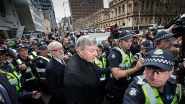 Cardinal George Pell, with his lawyer Robert Richter QC, leave court amid chaotic scenes.