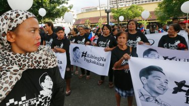 Supporters of the late Philippine dictator Ferdinand Marcos display his images prior to marching on Monday.