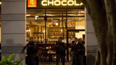 Israeli police officers stand guard at the scene of a shooting attack, outside a Max Brenner cafe, in Tel Aviv.
