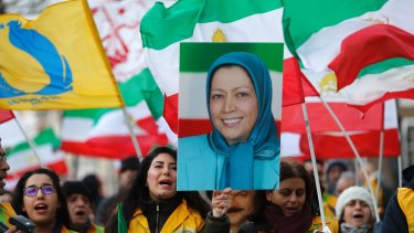 A woman holds up the image of Mujahideen-e-Khalq leader Maryam Rajavi outside 10 Downing Street in London during a demonstration by Britain's Iranian community. 