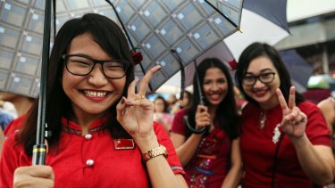 National League for Democracy (NLD) party supporters pose celebrate outside the party headquarters in Yangon on Sunday. 
