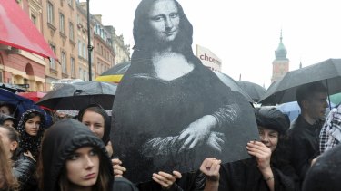 Dressed in black women carry a reproduction of the famous Leonardo Da Vinci painting, Mona Lisa, symbolising femininity, as they protest a proposed total ban on abortion.