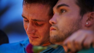 Austin Hagge, left, cries on the shoulder of Austin Matthew, during a candlelight vigil in Orlando. They lost two friends in the shooting.
