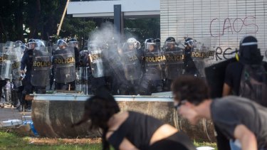 Protesters against Michel Temer throw projectiles at police in Brasilia.