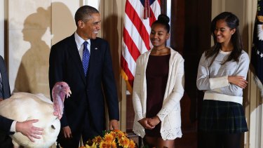 President Obama "pardons the turkeys" with his daughters Sasha and Malia. 