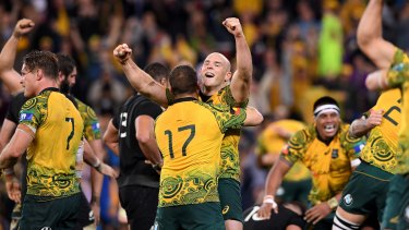Long time coming: Stephen Moore embraces Tom Robertson as the Wallabies celebrate a win over New Zealand - finally.