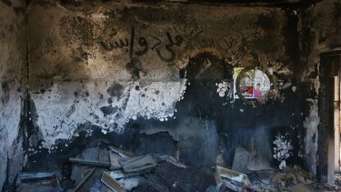 A child's burnt clothing and belongings can still be seen on the floor of the Dawabshe family home. Ali Dawabshe's name is written in Arabic on the wall.