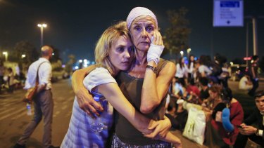 Passengers embrace as they wait outside Istanbul's Ataturk airport, following their evacuation after the attack.