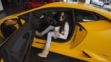 Chelsea Jiang sits in a car  at a Lamborghini dealership reception in Vancouver, British Columbia.