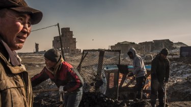 Workers sort coal at the Nalaikh mines on the outskirts of Ulaanbaatar. The air is cleaner in Nalaikh, despite the area being the primary source of the coal burned in the capital.