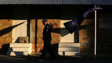 An Australian peacekeeping officer passes by an Australian Federal Police flag on the last day of duty.
