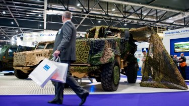 A visitor walks past the General Dynamics pavilion during the 2013 edition of the DSEI arms fair in London.