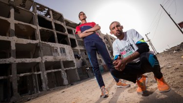Nader al-Masri (right) and Anas al-Masri  outside a building destroyed by Israeli bombardment in the Gaza Strip town of Beit Hanoun.