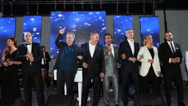 Secretary General of NATO, Jens Stoltvenberg, third right, Turkish foreign minister Mevlut Cavusoglu, centre, Greek foreign minister Nikos Kotzias, third left, EU foreign police representative for foreign policy, Federica Mogherini, second right, and other NATO officials sing <i>We Are the World</i>.
