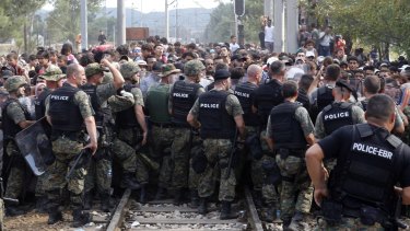 Macedonian police block migrants from entering Macedonia from Greece.