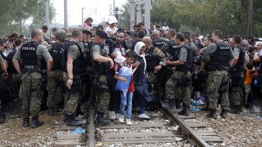 Macedonian police let migrants with children through. 