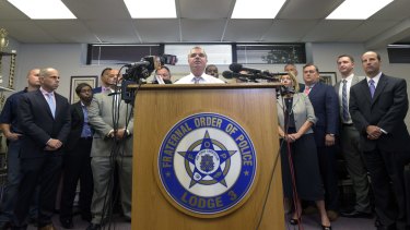 Gene Ryan, centre, president of the Baltimore Fraternal Order of Police, flanked by attorneys and accused police officers, speaks after prosecutors dropped remaining charges against the three officers awaiting trial in Freddie Gray's death.