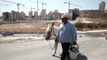 A Palestinian man walks near the construction site of a new housing unit in the East Jerusalem settlement of Har Homa, deemed illegal by the international community.