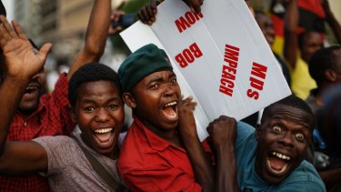 Zimbabweans celebrate Robert Mugabe outside Parliament on Tuesday.