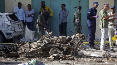 Somali soldiers stand near the wreckage of a car bomb in Mogadishu, Somalia, on December 19. Fears about Somalians in America link refugees to the wars and instability they fled.