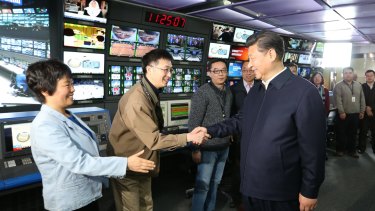 In this photo released by China's Xinhua News Agency, Chinese President Xi Jinping, right, shakes hands with staff members at the control room of China Central Television (CCTV) in Beijing in February.