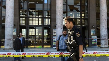 Turkish security forces and forensic police inspect the blast site after the explosions.