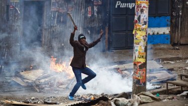 A man brandishing a "panga" machete challenges policee in the Mathare slum of Nairobi.