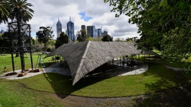 Indian architect Bijoy Jain's MPavilion sits against a backdrop of the city skyline in Melbourne's Queen Victoria Gardens 