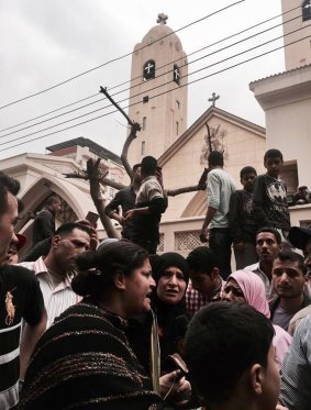 Relatives and onlookers gather outside a church after a bomb attack in the Nile Delta town of Tanta, Egypt.