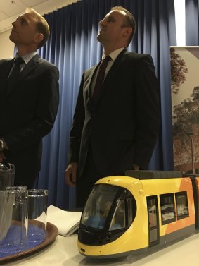 Simon Corbell, left, and Andrew Barr announcing the winning bidder for the Canberra tram, with a model of the Spanish-made trams. 