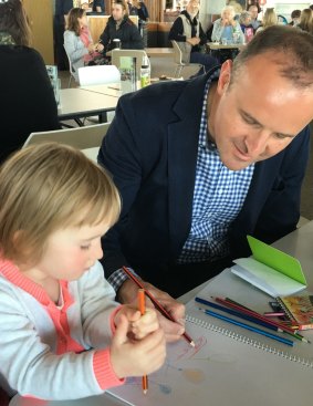Andrew Barr shows his niece Zoe Barr, 2, how to draw a tram.