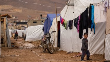 A young Syrian refugee walks past tents at the al-Nihaya camp in the eastern Lebanese town of Arsal, where some reports say Saja Hamid al-Dulaimi and her son were arrested.