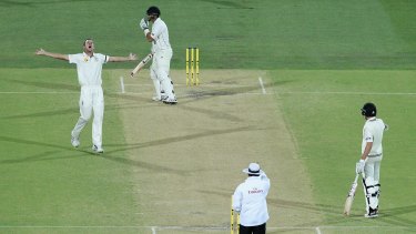 Out: Josh Hazlewood celebrates getting the wicket of Ross Taylor under lights.