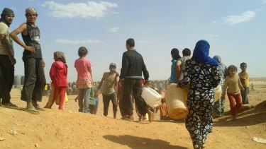 Syrian refugees gather for water at the Rukban refugee camp in Jordan's northeast border with Syria in June.