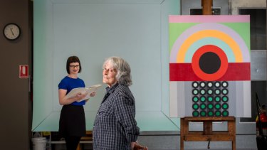 Artist Janet Dawson (front)  and NGV curator Beckett Rozentals, with John Peart's Corner square diagonal (rear) and James Doolin's Artificial landscape 67-6.