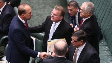 Mr Dutton is congratulated by colleagues after introducing the bill.
