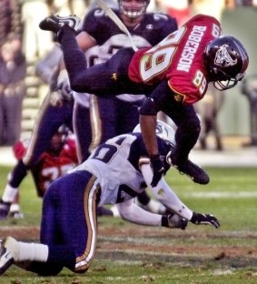 San Francisco Demons wide receiver Brian Roberson jumps over Los Angeles Xtreme cornerback Dell McGee.