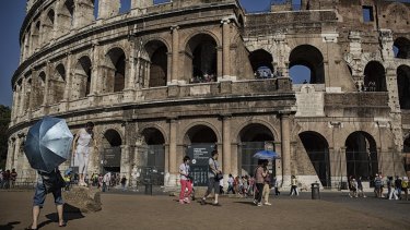 Tourists take photos in front of the Colosseum in Rome this week. 