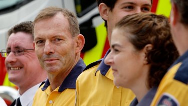 Prime Minister Tony Abbott prepares to receive a medal for 10 years of voluntary service to fire-fighting