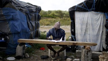 Faris, a Sudanese man, learns French at the 'jungle' camp in Calais in August. The shanty town, which is home to thousands of refugees, will soon receive the materials from Banky's "bemusement park".