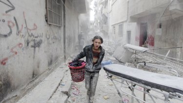 A boy carries his belongings at a site that was reportedly hit by a barrel bomb dropped by the Syrian Air Force in Aleppo's al-Fardous district in April.