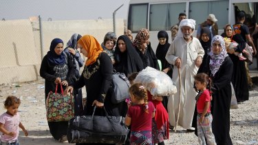 Displaced Iraqi families arrive to an Iraqi army camp during fighting between Iraqi security forces and IS on Saturday.