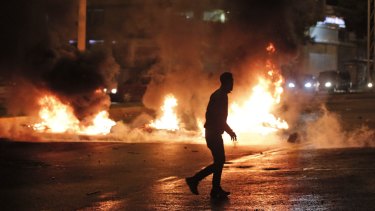 A masked protester runs past garbage set on fire by supporters of the pro-Kurdish Peoples's Democratic Party (HDP) in Diyarbakir, in Turkey's predominantly Kurdish southeast, on Sunday. 