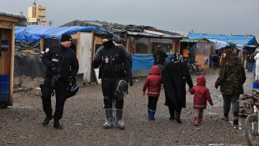 French riot police officers patrol in the migrant camp in Calais, north of France, earlier this month. 